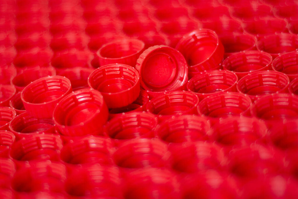 переработка пластика концепции. красный абстрактный фон пластиковых колпачков из бутылки, вид сверху, короткий фокус - Фото, изображение