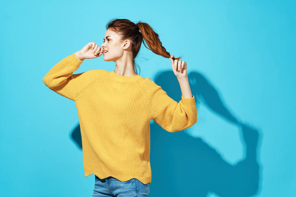 pretty woman in yellow sweater attractive look emotions close-up blue background - Фото, зображення