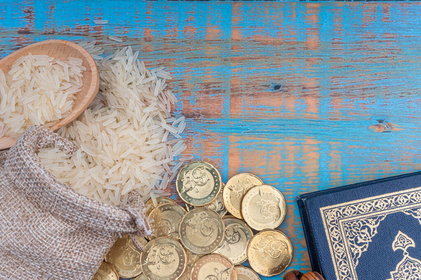 heiliger Quran, Münzen, Rosenkranz und Reis. zakat Konzept. zakat ist eine Form von Almosen als religiöse Verpflichtung  - Foto, Bild