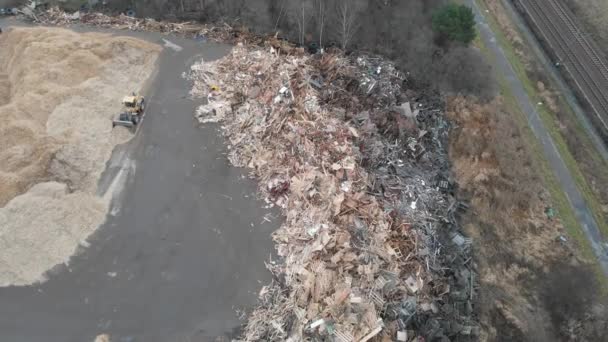 トラクターフロントローダー木製の廃棄物埋め立て地でのおがくずの移動、空中暴露 - 映像、動画