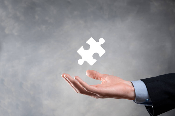 Üzletember kéz összekötő puzzle darabok képviselő egyesítése két vállalat vagy közös vállalat, partnerség, egyesülések és akvizíció koncepció - Fotó, kép