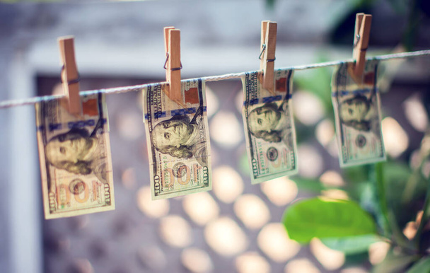 Банкноты в долларах США висят на веревке за отмывание денег - Фото, изображение