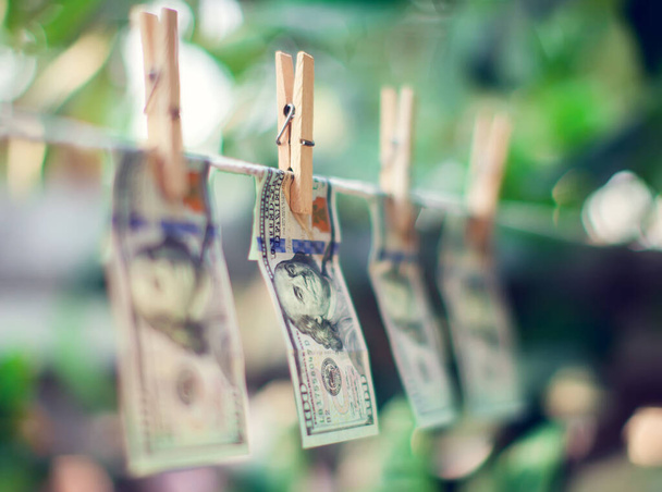 Τραπεζογραμμάτια σε δολάρια ΗΠΑ που κρέμονται σε σχοινί για ξέπλυμα χρήματος - Φωτογραφία, εικόνα