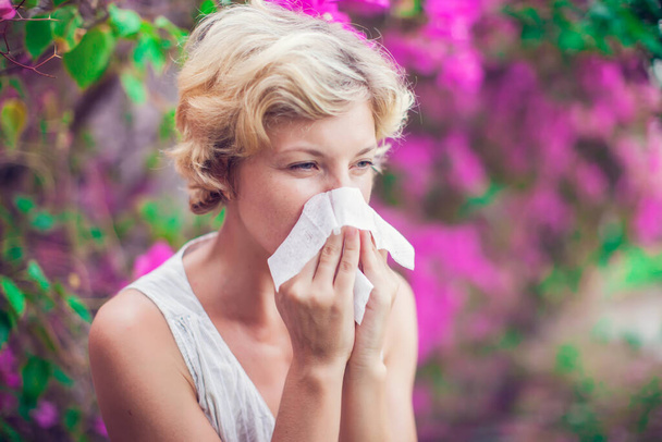 Frau mit Allergie-Symptom pustet Nase - Foto, Bild