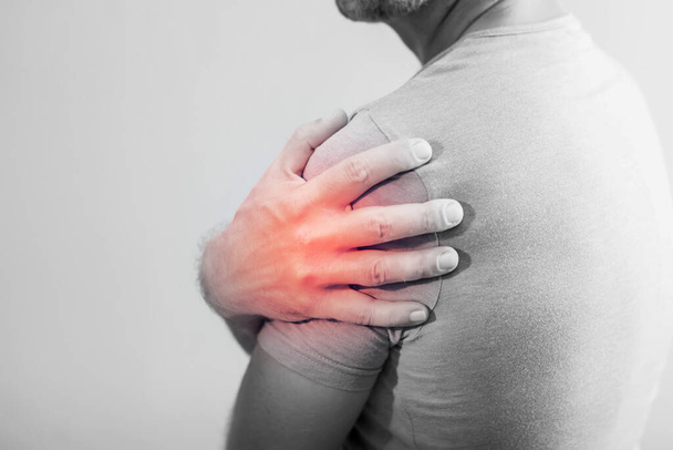 Close-up van Man met schouderpijn of nekpijn op witte achtergrond, Gezondheidsconcept - Foto, afbeelding