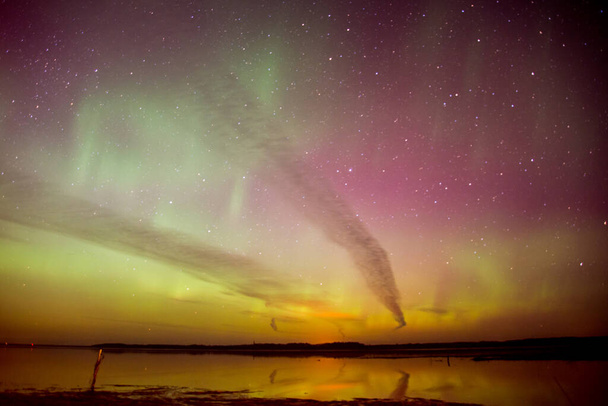 Intense northern lights aurora borealis over beach in Latvia - Photo, Image