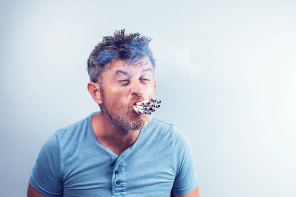 Junger Mann mit vielen Zigaretten im Mund - Foto, Bild