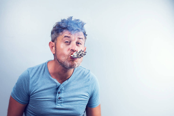 Jeune homme avec beaucoup de cigarettes dans la bouche - Photo, image