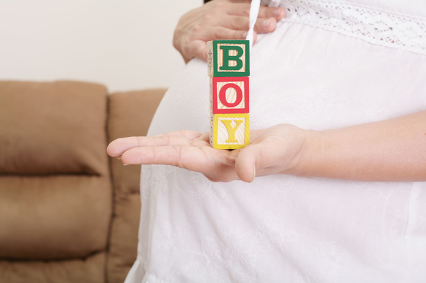 беременная женщина, имеющая слово "мальчик" с деревянными блоками написано
  - Фото, изображение