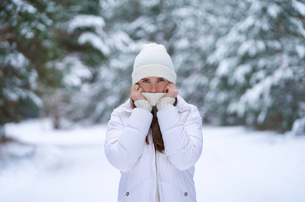 hermosa mujer joven sonriente en invierno al aire libre. Concepto de invierno. ropa blanca, nieve, bosque, clima frío, congelado - Foto, Imagen