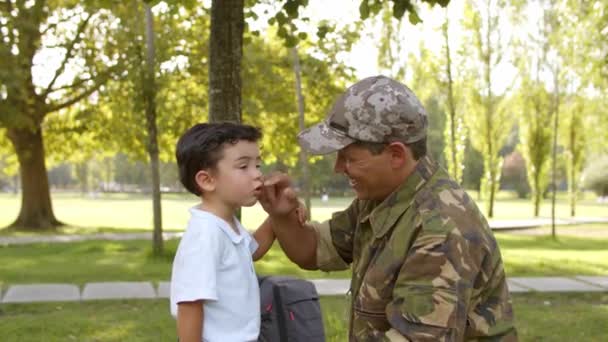 Ευτυχισμένος στρατιωτικός μπαμπάς απολαμβάνει ελεύθερο χρόνο με το γιο του στο πάρκο - Πλάνα, βίντεο