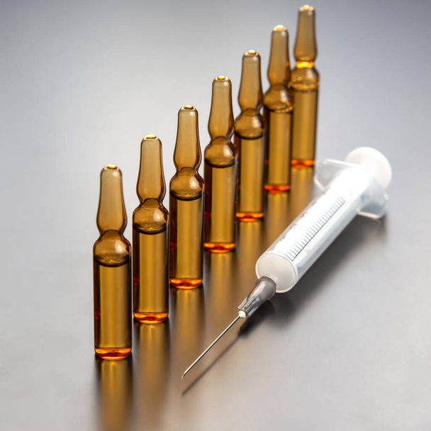 sept ampoules en verre médical pour injection de drogue sur fond gris - Photo, image