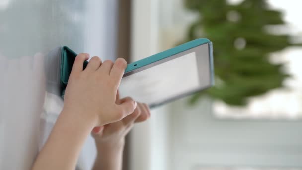 Vorschulkind sitzt an einem Tisch und blickt auf ein digitales Tablet - Filmmaterial, Video