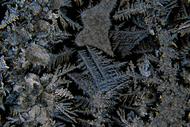 Makro různých abstraktních tvarů krystalů ledu na skleněném okně s černým pozadím - Fotografie, Obrázek