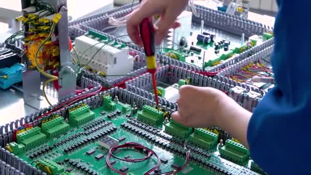 Nahaufnahme des Elektrikers, der mit Kabeln und Drähten am Fließband arbeitet, die Installation des Transformators - Filmmaterial, Video
