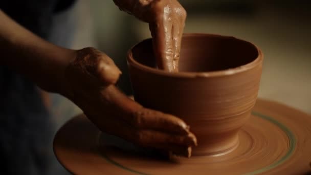 Girl shaping clay product in pottery. Woman sculpting clay pot in workshop - Footage, Video