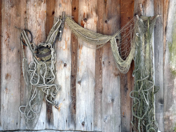 Vieja red de pesca está colgando en la pared de madera - Foto, imagen