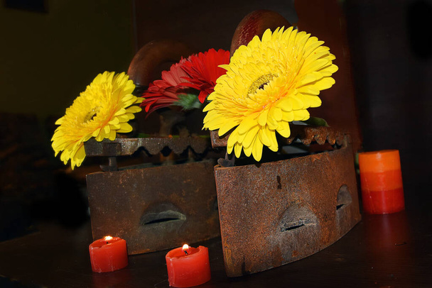 oude retro metalen ijzers en bloemen met kaarsen op donkere achtergrond, dichtbij uitzicht  - Foto, afbeelding