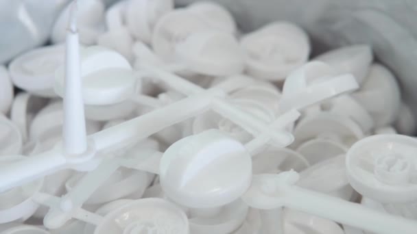 Um grande número de pequenas peças de plástico branco na fábrica - Filmagem, Vídeo