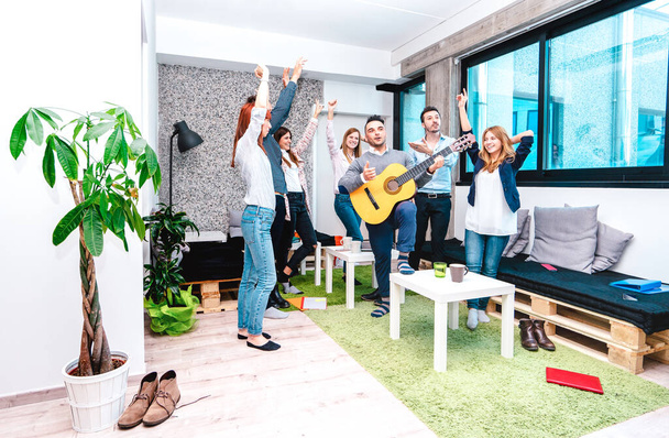 Jóvenes trabajadores asalariados descansando en el espacio de coworking de inicio - Divertido concepto de negocio de recursos humanos descansando en el lugar de trabajo - Empresarios de startups bailando en la fiesta de oficina - Foto, Imagen