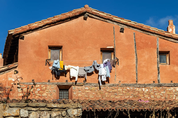 Antigua casa con ropa lavada colgando de las cuerdas colgando de las ventanas. Albarracina España - Foto, Imagen