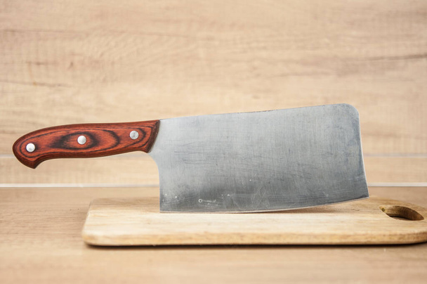 Tábua de corte e uma faca de cozinha no fundo de madeira velha.  - Foto, Imagem