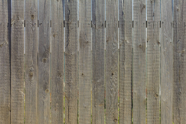 Wooden background.A rustic fence made of unpainted boards with slits and nails. - Photo, Image