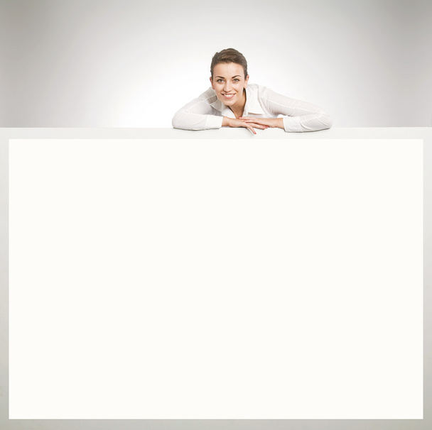 Beautiful businesswoman showing empty white board - Foto, imagen