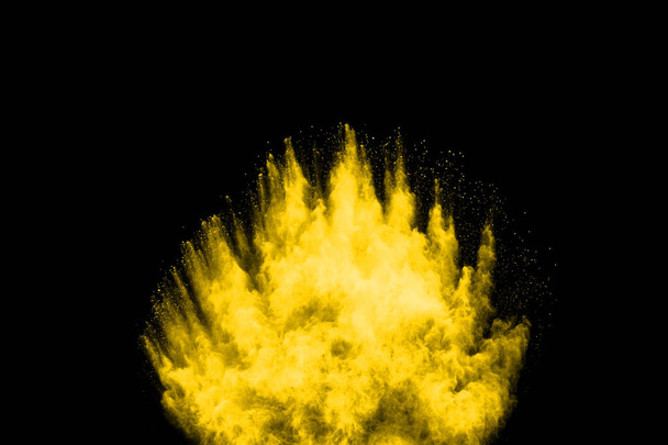 Παγωμένη κίνηση της έκρηξης κίτρινης σκόνης που απομονώνεται σε μαύρο φόντο. - Φωτογραφία, εικόνα