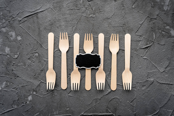 Wooden knife and fork on the black background. Eco friendly zero-waste concept. Top view with space for text Copy space - Photo, Image