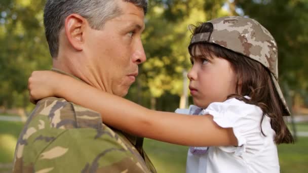 Ευτυχισμένος στρατιωτικός μπαμπάς που βάζει καπέλο καμουφλάζ στην κόρη - Πλάνα, βίντεο