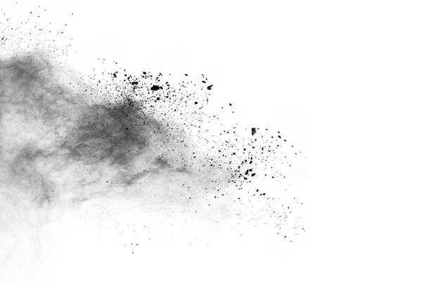 partículas de carbón vegetal sobre fondo blanco, polvo abstracto salpicado sobre fondo blanco, congelar el movimiento del polvo negro explotando o lanzando polvo negro. - Foto, Imagen