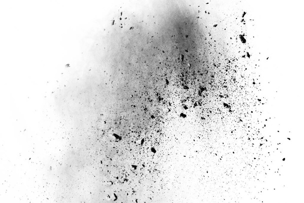 deeltjes houtskool op witte achtergrond, abstract poeder gespoten op witte achtergrond, Freeze beweging van zwart poeder exploderen of gooien zwart poeder. - Foto, afbeelding