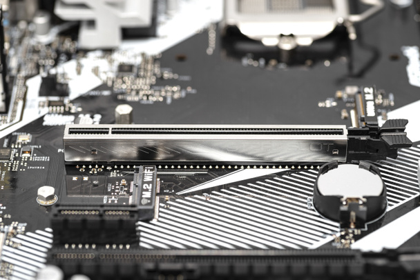 A macro shot of a PCI Express 3.0 x16 steel slot connector on a modern desktop motherboard. - Photo, Image