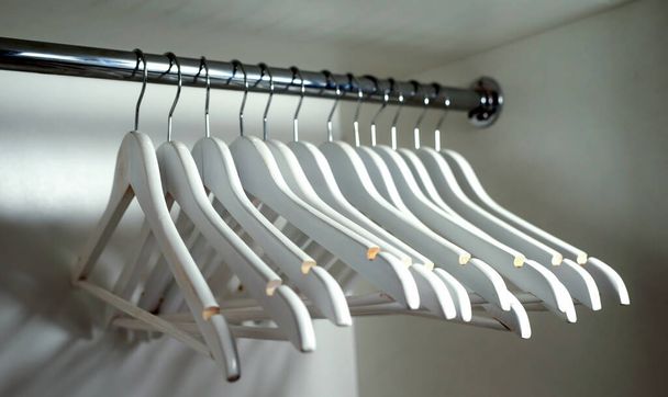 Wooden white clothes hangers inside the closet - Photo, Image