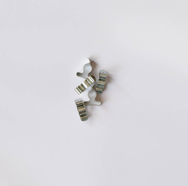 Куча серебряных зажимов проволоки на белом фоне с копировальным пространством - Фото, изображение