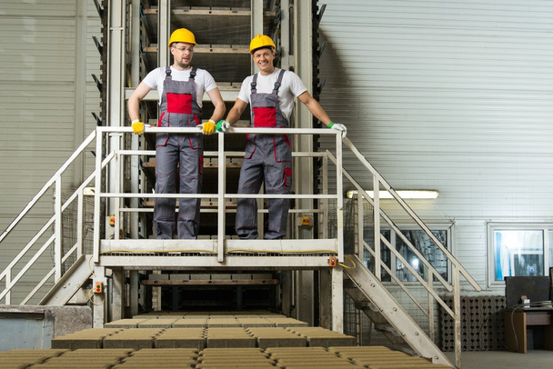 Two men in a safety hats on a factory   - Fotografie, Obrázek