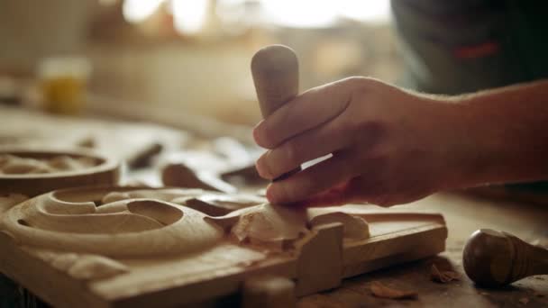 Unbekannter verziert Holz im Haus. Kerl schnitzt Ornament in Tischlerei - Filmmaterial, Video