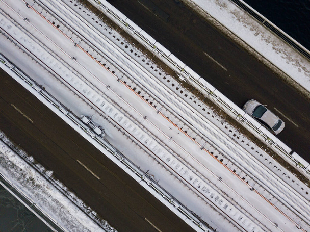 Hóval borított metró híd Kijevben. Felhős téli reggel. Légi drónra néző. - Fotó, kép