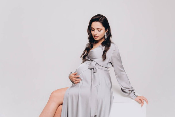 Фотосесія вагітності красивої пари, майбутні батьки в сірій сукні і костюмі
 - Фото, зображення