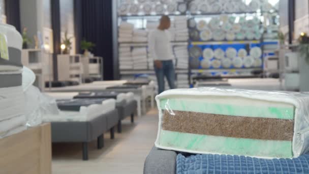 Man shopping for new bed and mattress at furnishings store - Footage, Video