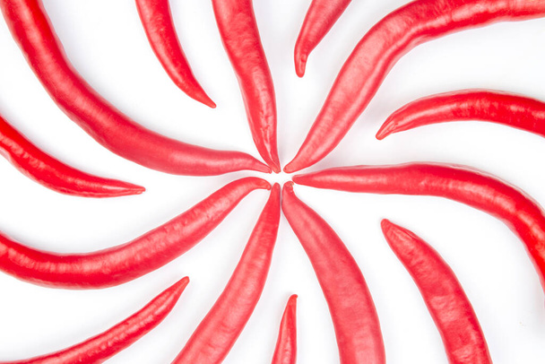 Κόκκινες καυτερές πιπεριές τσίλι σε λευκό φόντο. φιγούρες. Φυτικές τροφές βιταμινών - Φωτογραφία, εικόνα