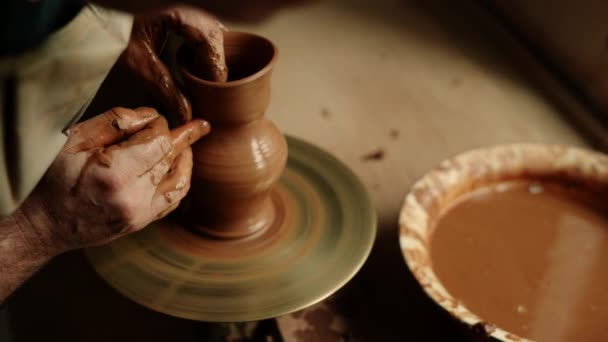 Keramist produceren klei pot in aardewerk. Onherkende man die met natte klei werkt  - Video