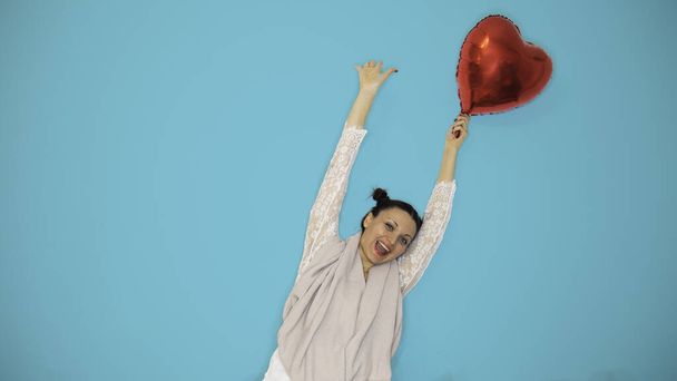 Smiling for summer with a red heart balloon on a blue background. Negative space or copy space for text. - Photo, Image
