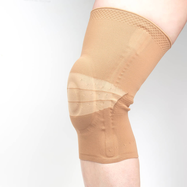 bandagem para fixar o joelho lesionado da perna humana em um fundo branco. medicina e esportes. tratamento de lesões nos membros - Foto, Imagem