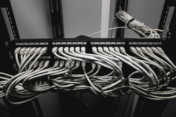 Beaucoup de câbles réseau connectés dans un gros commutateur réseau. - Photo, image