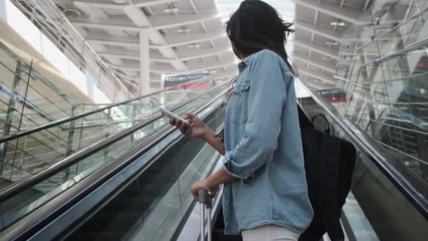 mujer joven levantamiento de pasajeros en la escalera en movimiento en la estación de tren - Metraje, vídeo