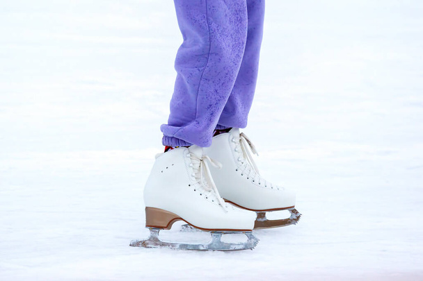 piernas de un patinador en una pista de hielo. pasatiempos y deportes de invierno - Foto, Imagen