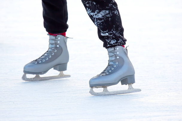 pies en los patines de una persona rodando en la pista de hielo - Foto, imagen