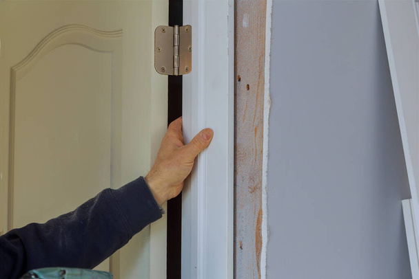 新しい住宅プロジェクトの内装工事における屋内ドアの男性のインストールの閉鎖 - 写真・画像